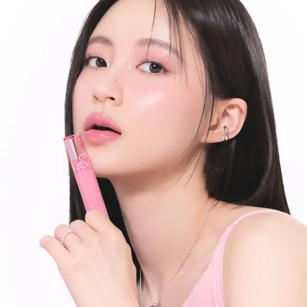 rom&nd Glasting Color Gloss held beside glossy pink lips