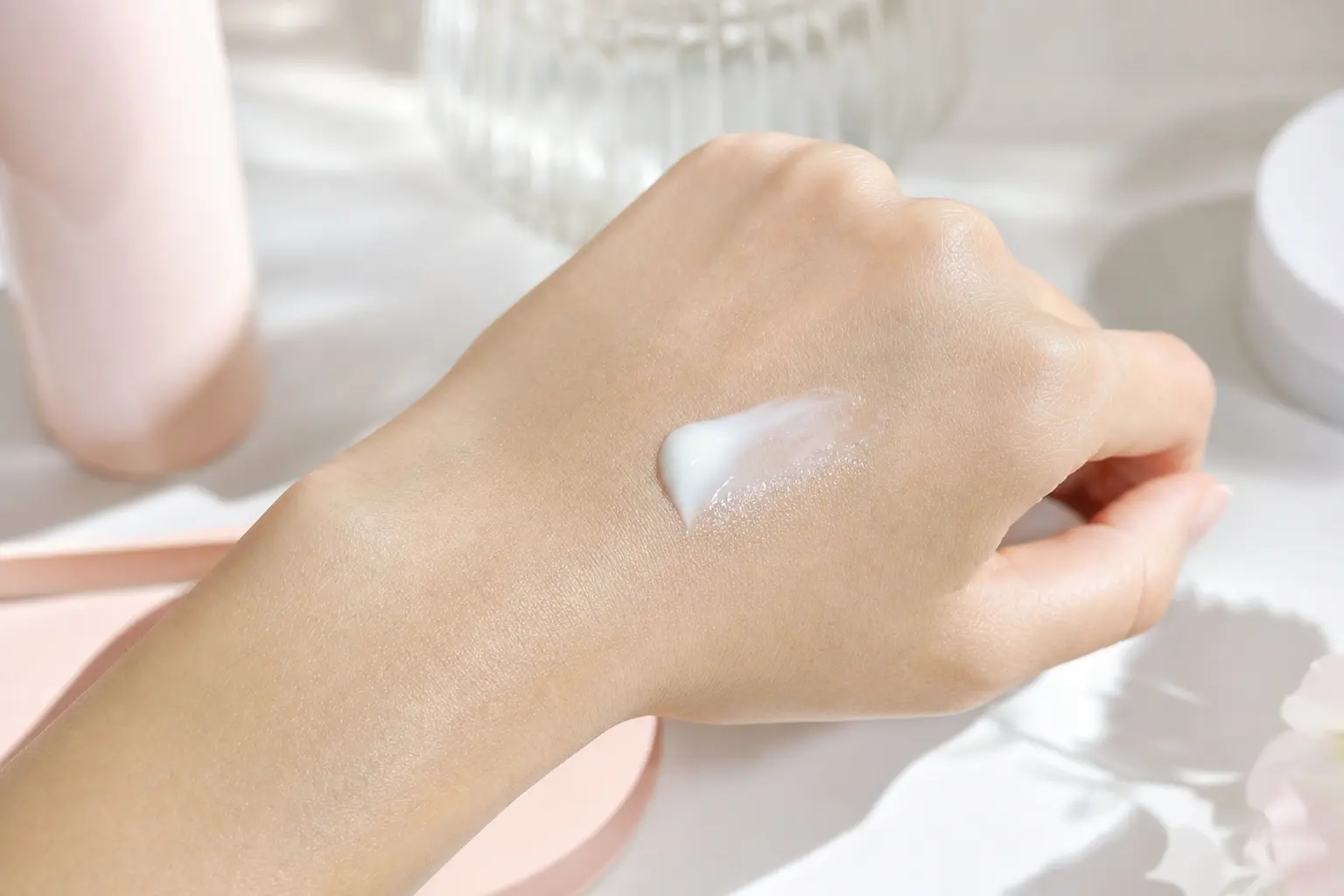 A textured shot of a pea-sized dollop of gel sunscreen on the back of a hand, showing a semi-matte finish and lightweigh